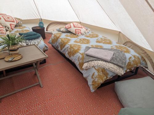 a room with two beds and a table in a tent at Stay Wild Retreats 'Glamping Pods and Tents' in Wrexham