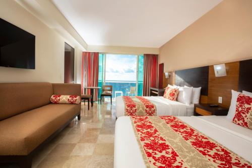 a hotel room with two beds and a couch at Krystal Cancun in Cancún
