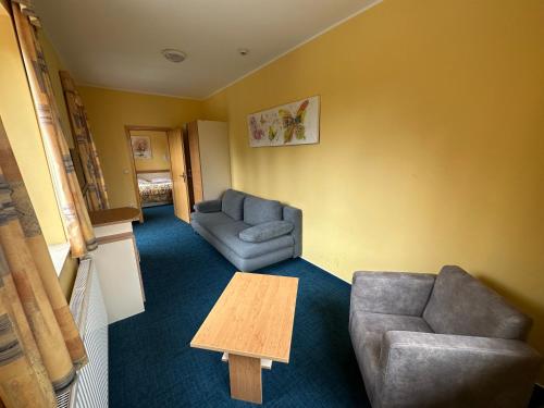 a living room with two chairs and a table at Hotel Zarja in Pohorje