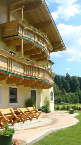 a building with wooden benches in front of it at Bio-Bauernhof Obertrattenbachhof in Neukirchen am Großvenediger