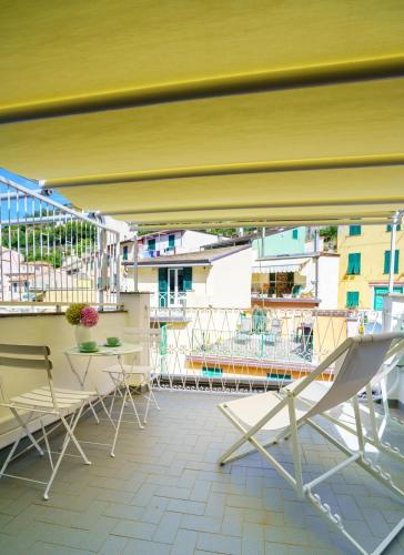 a balcony with chairs and tables on a building at Sotto Sale-5 Terre affittacamere in Riomaggiore