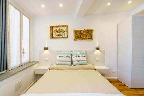 a white bedroom with a large bed with two pillows at Sotto Sale-5 Terre affittacamere in Riomaggiore