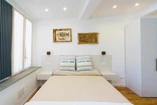 a white bedroom with a bed and a window at Sotto Sale-5 Terre affittacamere in Riomaggiore