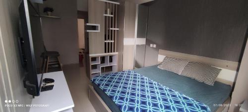 een kleine slaapkamer met een bed en een televisie bij CITRA INN in Tangerang