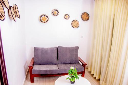 ein Wohnzimmer mit einem Sofa und einem Tisch in der Unterkunft Mwiza in Kigali