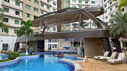 a swimming pool with a walkway in a building at Riviera Park Hotel Luxo in Caldas Novas
