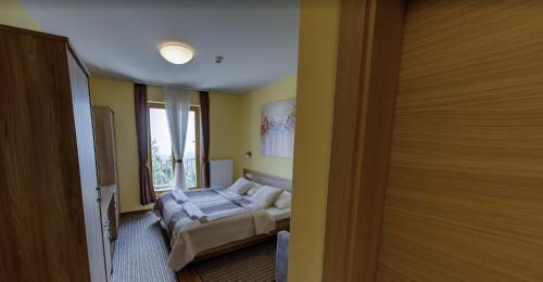 a bedroom with a bed and a window at Hotel Zarja in Pohorje
