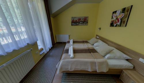 a large bed in a room with a large window at Hotel Zarja in Pohorje
