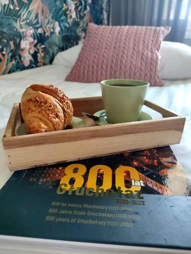 a tray of bread and a cup on top of a book at Apartament ''Na Szlaku'' in Głuchołazy