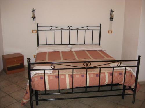 a bed in a room with a black metal bed frame at Il Molino Della Contessa in Castelmezzano