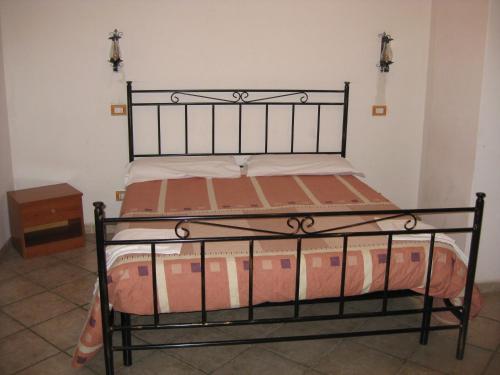 Cama en habitación con marco de cama de metal negro en Il Molino Della Contessa, en Castelmezzano