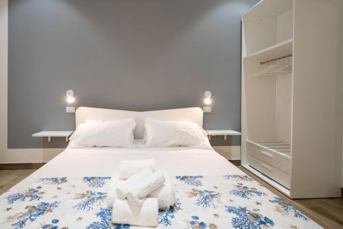 sypialnia z białym łóżkiem i ręcznikami w obiekcie All'Imbarco w mieście La Spezia