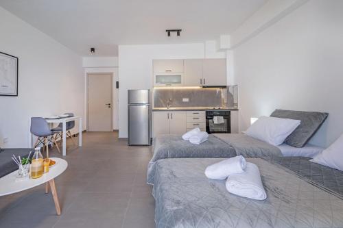 a room with two beds and a kitchen at 777 Studios Corfu in Agios Ioannis