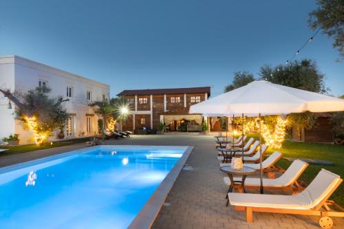a swimming pool with lounge chairs and an umbrella at Li Canali Reali in Mesagne