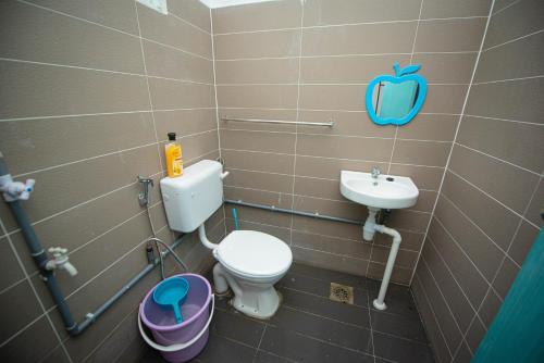 La salle de bains est pourvue de toilettes et d'un lavabo. dans l'établissement MKB Homestay, à Shah Alam