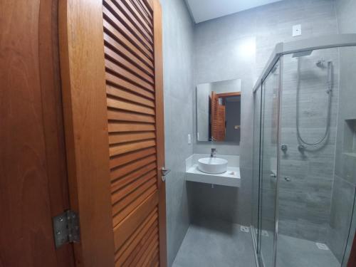 y baño con ducha acristalada y lavamanos. en Meu Dengo Pousada, en Morro de São Paulo