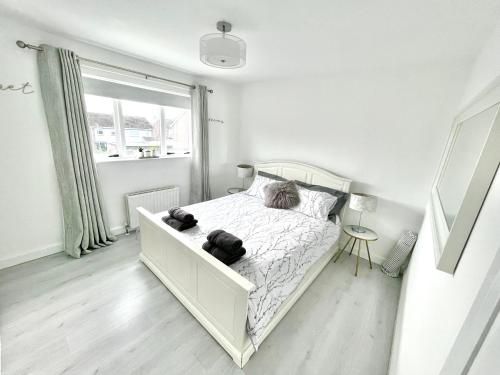 a white bedroom with a bed and a window at The Bay house in Derry Londonderry