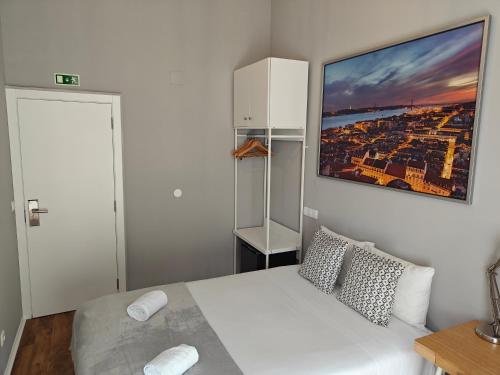 een slaapkamer met een wit bed met een foto aan de muur bij Great Stay Fanqueiros 5 & 2 in Lissabon