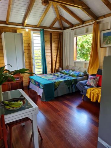 ein Schlafzimmer mit einem Bett und einem Sofa in einem Zimmer in der Unterkunft La kaz nature bien-être in Petit-Bourg