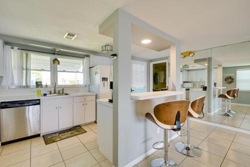 a kitchen with white cabinets and a table and chairs at New Port Richey Oasis with Private Pool! in New Port Richey