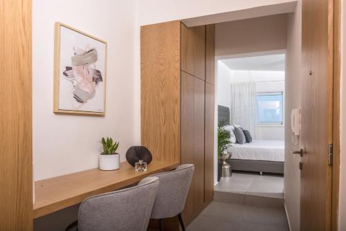 a room with a desk and a bedroom with a bed at Loggia Suites by Good Life in Heraklio