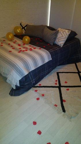 - un lit avec des pétales de rose rouge au sol dans l'établissement Châlet lâché prise, 