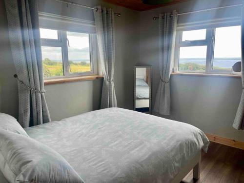 sypialnia z łóżkiem i 2 oknami w obiekcie Tigh Seoighe - Renovated Cottage Tourmakeady w mieście Toormakeady