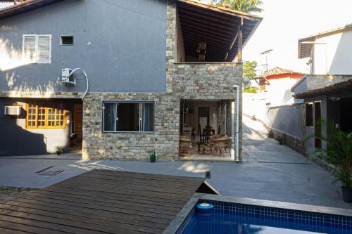 a house with a swimming pool in front of it at Casa Jaguar suites 150 mt da praia geriba in Búzios