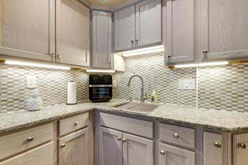 a kitchen with white cabinets and a sink at 3 Mi to Dtwn Springfield Home with Deck! in Springfield