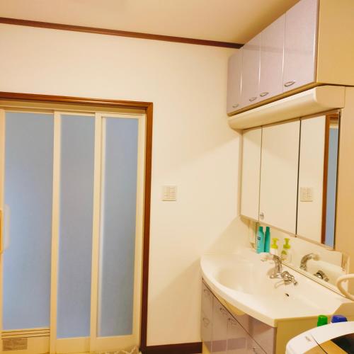 a white bathroom with a sink and a shower at STAYAI in Ibaraki