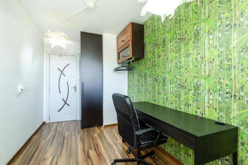 a room with a green wall with a desk and a speaker at The White Apartment 3BR - free parking in Sofia