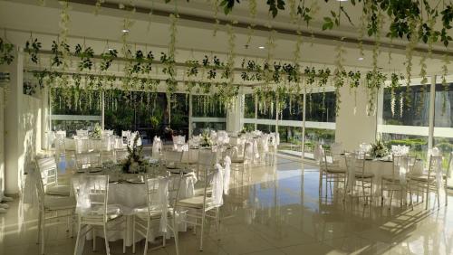 a banquet hall with white tables and chairs and plants at Hotel Palmeras De Luz in Moniquirá
