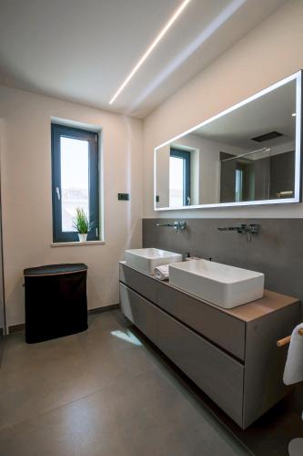 a bathroom with two sinks and a large mirror at Villa FGstar in Murter