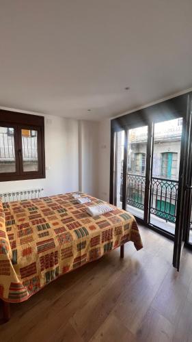 a bedroom with a bed in a room with windows at A de Juan - Tres Marias Apartments in Redondela