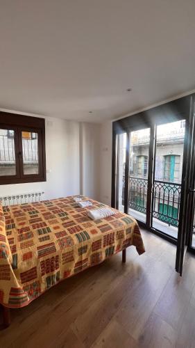 Un dormitorio con una cama en una habitación con ventanas. en A de Juan - Tres Marias Apartments, en Redondela