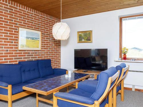 uma sala de estar com uma mesa e cadeiras azuis em 7 person holiday home in Fr strup em Frøstrup