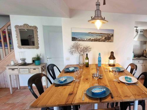 une table en bois avec des chaises et une salle à manger dans l'établissement Les pieds dans l'eau :KER ANNE (chez ANNE), à Port-Joinville