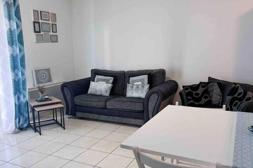 a living room with a couch and a table at Appart avec terrasse à 2 pas de Disney in Montévrain