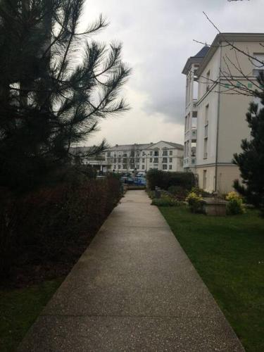 a walkway in front of a large white building at Appart avec terrasse à 2 pas de Disney in Montévrain