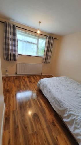 Ένα ή περισσότερα κρεβάτια σε δωμάτιο στο offering cheerfull and spacious rooms throught this 3 bed room semi detached house with large garden and off-street parking.