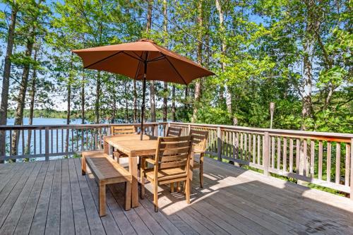 a wooden table and chairs with an umbrella on a deck at Equanimity in Eagle River