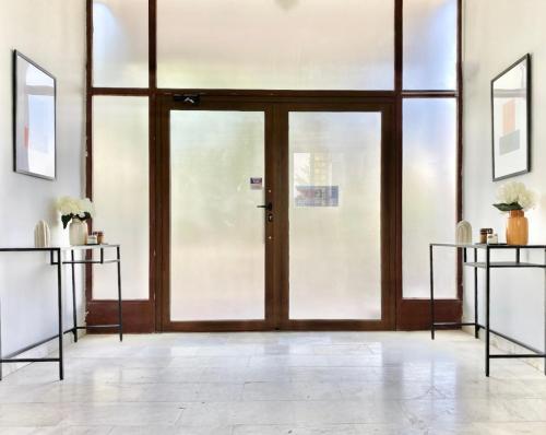 a glass door in a room with two tables at Hello Studios Budget Stays Free Parking & Wifi in Stara Zagora