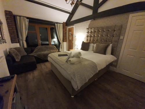 ein Schlafzimmer mit einem großen Bett und einem Sofa in der Unterkunft Thorpe Thewles Suites in Stockton-on-Tees