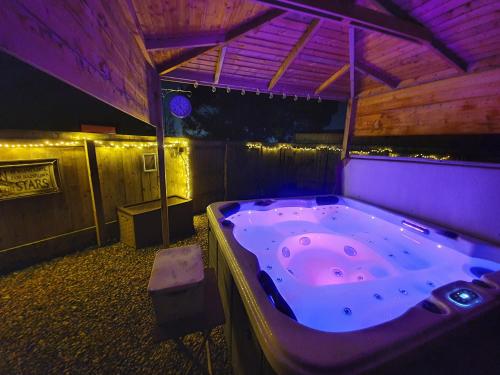 eine große Badewanne in einem Zimmer mit lila Beleuchtung in der Unterkunft Thorpe Thewles Suites in Stockton-on-Tees