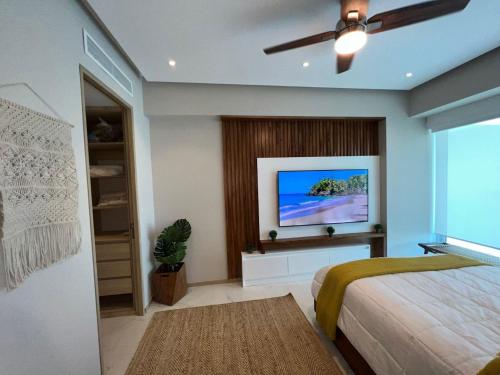 een slaapkamer met een bed en een flatscreen-tv bij Marítima Golf Luxury Department 2BR in Bucerías