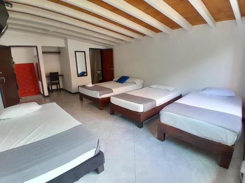 pokój z 3 łóżkami w pokoju w obiekcie Hotel Palermo Real w mieście Medellín