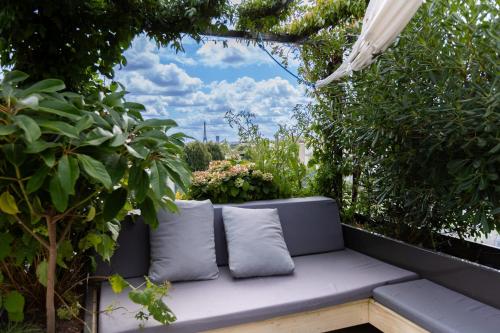a couch sitting on a patio with plants at Splendid apartment and rooftop overlooking Paris - Neuilly - Welkeys in Neuilly-sur-Seine