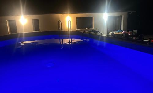 a dark room with a swimming pool at night at Chambre Privée Accès Piscine in Mimizan