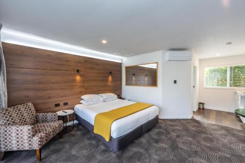 a hotel room with a bed and a chair at The Ashley Hotel Greymouth in Greymouth