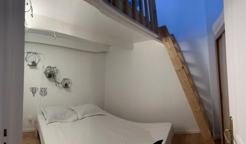 een witte kamer met een bed en een trap bij Maison de campagne in Tourrettes